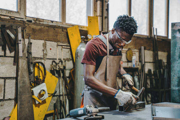 industrial welder working with hammer and chisel - protective glove machinist human hand african descent imagens e fotografias de stock