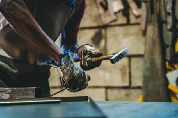 industrial welder working with hammer and chisel - protective glove machinist human hand african descent imagens e fotografias de stock