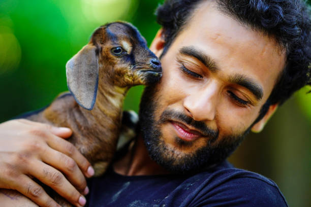 istock boy with cute baby goat pet animal 1399217416