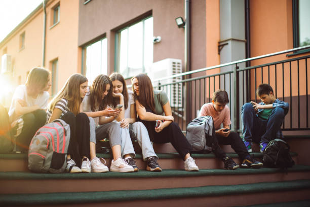 istock Teenage students have fun and conversation using their mobile phones in schoolyard 1399217749