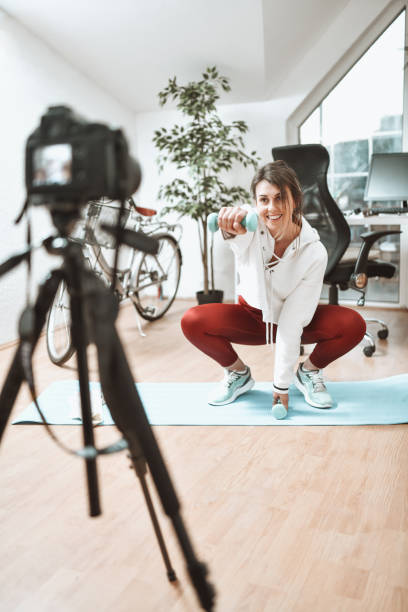 istock Smiling Female Recording Vlog While Doing Home Exercises 1399219261
