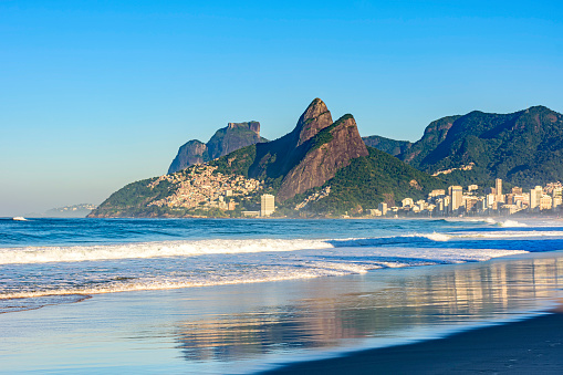 Dawn in the city of Rio de Janeiro with the empty Ipanema beach with the reflection of the buildings in the wet sand