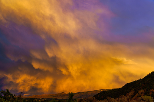 Light from a setting sun casts its colors on clouds from a passing rainstorm in Northern Arizona