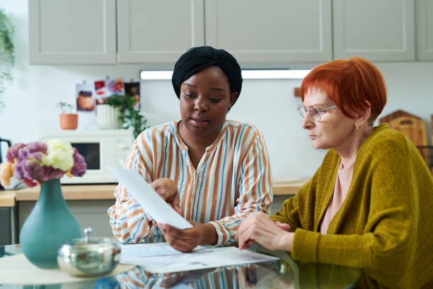 volunteer helping senior woman with bills - adult senior adult black white imagens e fotografias de stock