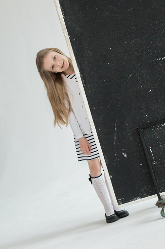 Girl in a white dress and in a white photo studio