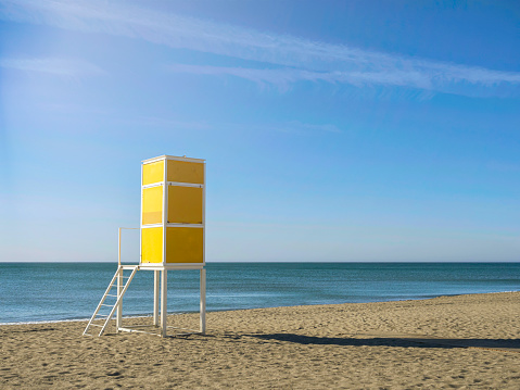 Lifeguard station, lifeguard tower on the beach in Torremolinos, Spain. Mediterranean summer sea in Spain. Iconic yellow lifeguard station. Summer vacations.
