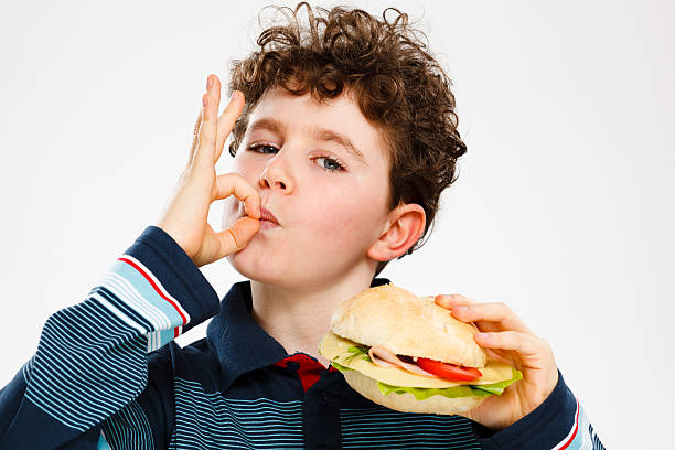 istock Boy eating hamburger showing OK sign 139923059