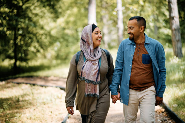 istock Happy Middle Eastern couple holding hands while walking through the park. 1399233164