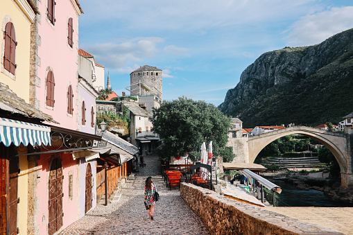 Tourist woman sightseeing the small old town of Mostar, in Bosnia Herzegovina.