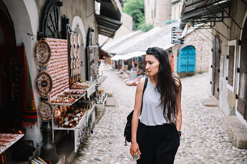 Tourist woman sightseeing the small old town of Mostar, in Bosnia Herzegovina.