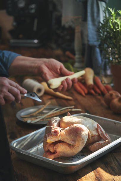 istock Preparing Roasted Chicken with Root Vegetables in Domestic Kitchen 1399238187