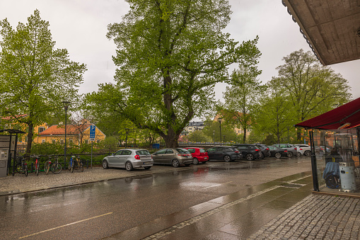 Sweden. Uppsala. 05.14.2022. Beautiful city landscape view on cloudy rainy day. Car parking in downtown in old European city.