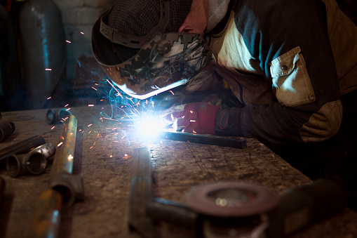Industrial worker in the production of metal products, welding close-up