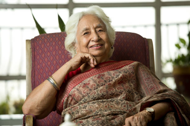 istock Old woman smiling while sitting on chair 1399241716