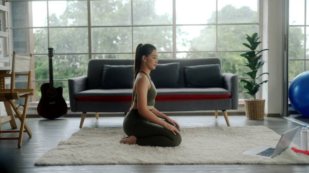 istock Asian woman practicing yoga at home 1399247017