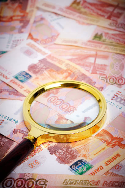 istock Magnifying magnifier against background Russian rubles with face value five thousand. 1399249433