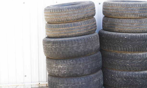 istock Changing car tires. Old rubber tires in the trash. Car dump. 1399249642
