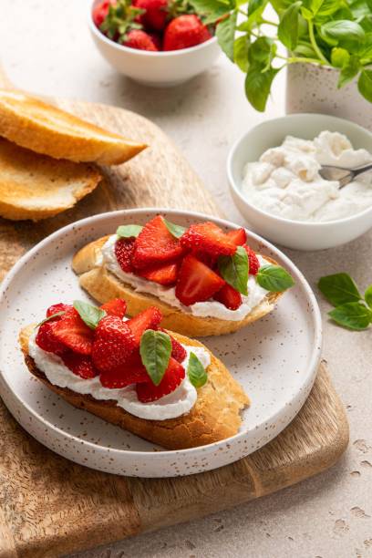 istock Bruschetta with goat cheese or ricotta witn strawberry and basil. Appetizer with berries. Summer healthy breakfast. Selective focus. 1399251101