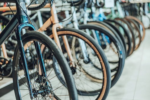 Bicycles parked in a bike shop\nView of front wheels and tires, Selective Focus