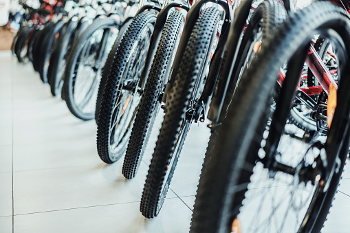 Bicycles parked in a bike shop\nView of front wheels and tires, Selective Focus