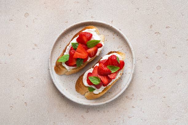 istock Bruschetta with goat cheese or ricotta witn strawberry and basil. Appetizer with berries. Summer healthy breakfast. Top view. 1399252839