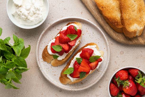 istock Bruschetta with goat cheese or ricotta witn strawberry and basil. Appetizer with berries. Summer healthy breakfast. Top view. 1399252841