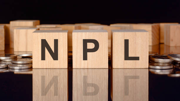 istock npl - text on wood blocks on black background with coins. front view. business concept 1399254346