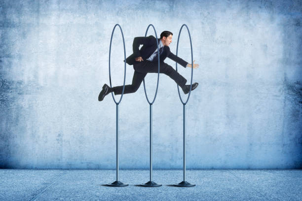 Businessman Jumping Through Series Of Hoops