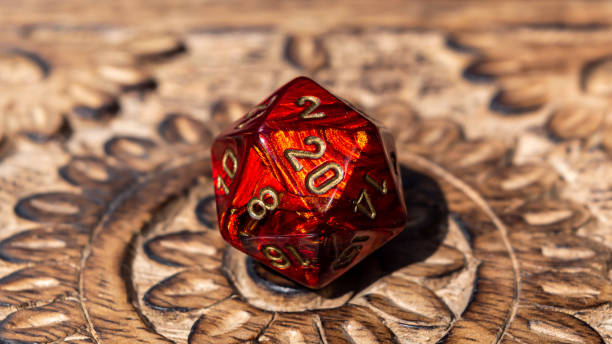 Close-up image of a red d20 on a wooden surface stock photo