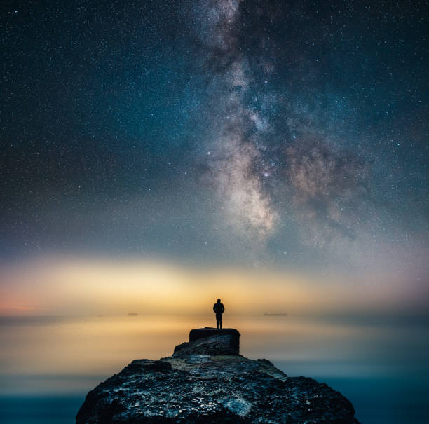 istock Man standing under the Milky Way by the sea 1399262589