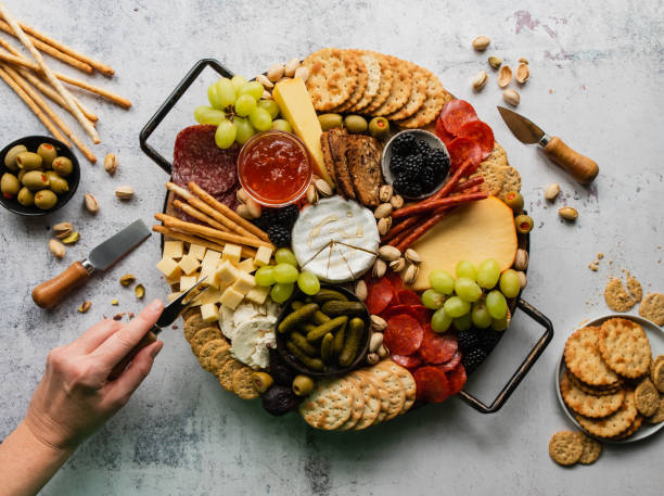 istock Hand sampling charcuterie board of meat, cheese, fruit, crackers. 1399264516