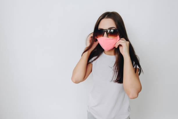 istock The model is dressed in a protective stylish handmade mask, large sunglasses on a white isolated background 1399264658