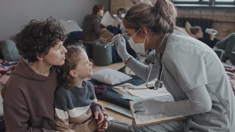 Nurse Examining Child in Refuge