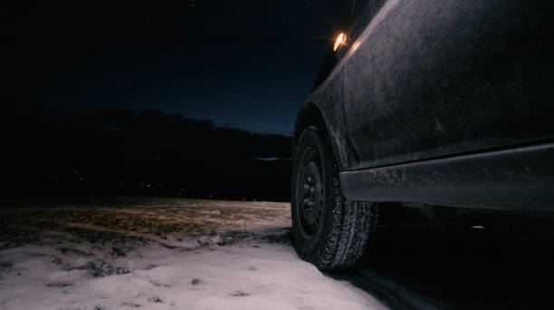 istock Man changing car tyre at night on winter road. 1399276571