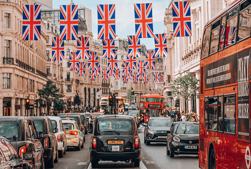 Central London,England,United Kingdom-August 21 2019:On a summer day,Union Jack flags fly over the sunny,quintessential streets of the vibrant English capital.