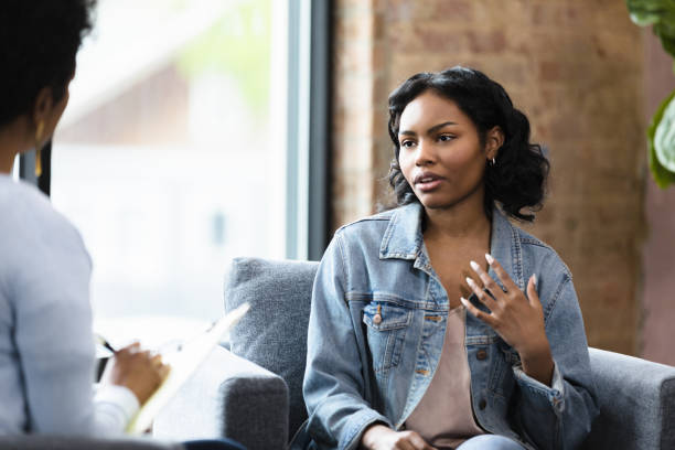 istock Depressed young adult woman gestures while sharing problems in therapy 1399285412