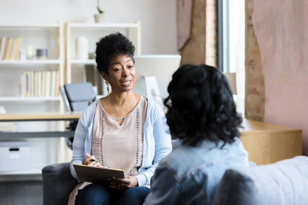 la consejera madura da consejos irreconocibles para una joven - mental health professional psychiatrist therapy teenager fotografías e imágenes de stock