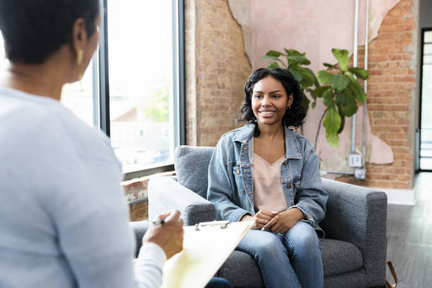 Young woman smiles while answering therapist's questions stock photo
