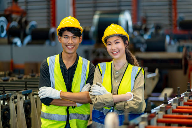 retrato del sonriente equipo de jóvenes ingenieros técnicos asiáticos dentro de la línea de producción de la fábrica de fabricación - industry portrait production line factory fotografías e imágenes de stock