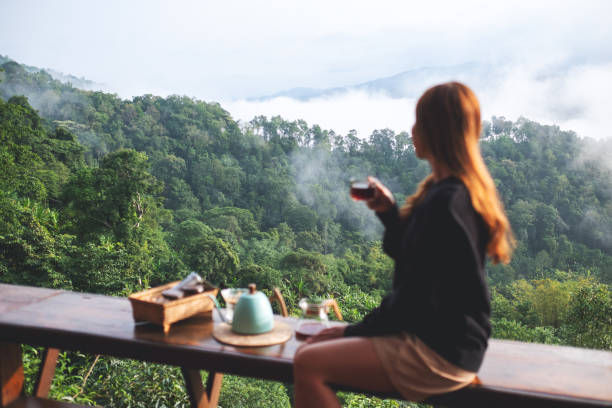 istock Blurred of a young woman making and drinking drip coffee while looking at a beautiful mountain and nature view 1399294584