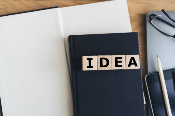 istock Wooden cube with IDEA with book, laptop and tablet. Business working or education learning success idea. Businessperson or student knowledge, creativity and skill improvement. 1399297445