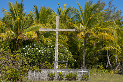 A large cross in the tropical landscape of Niau, one of the small atolls of the Tuamotu archipelago, French Polynesia on 6th May 2022. Catholic tradition is followed on French Polynesian islands like Niau.