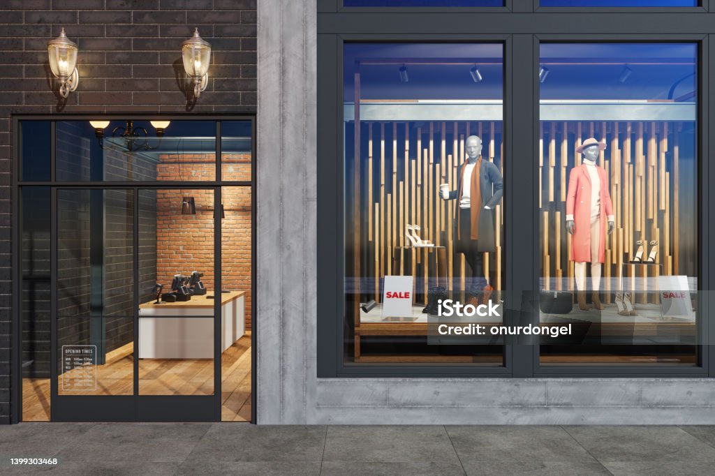 Facade Of Clothing Store With Mannequins, Clothes And Shoes Displaying In Showcase Store Stock Photo