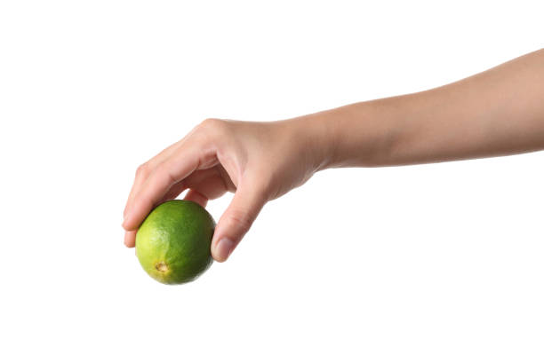 Hand squeeze green lime on white background stock photo