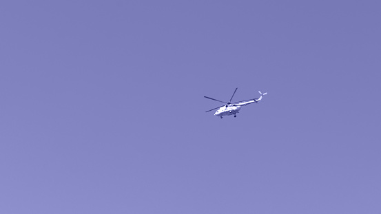 Blue helicopter in flight above Barcelona embankment