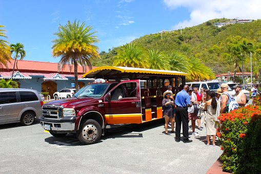 St. Thomas, USVI - May 4, 2022: The people at excursion or tour by bus on St. Thomas, USVI in US Virgin Islands - travel concept. Transporation to a beach on a from a boat dock to the beach on a Caribbean island. Sightseeing car