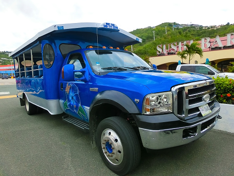 St. Thomas, USVI - May 4, 2022: The excursion or tour by bus on St. Thomas, USVI in US Virgin Islands - travel concept. Transporation to a beach on a from a boat dock to the beach on a Caribbean island. Sightseeing car