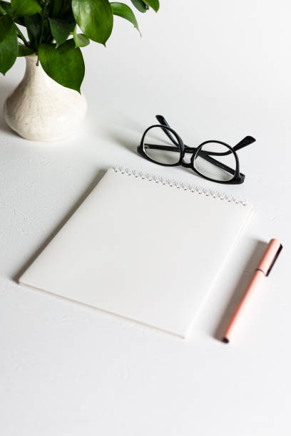 istock A white blank spiral notebook with a pen is lying on a white table 1399314680