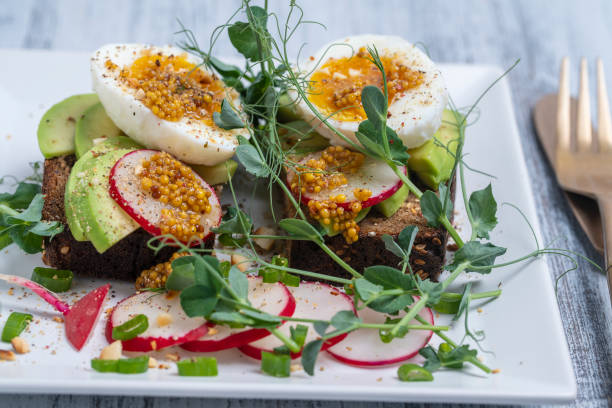 istock Bread toast, boiled eggs, avocado slice, pea microgreens and fresh radish on a white plate in a cafe, breakfast time 1399314886