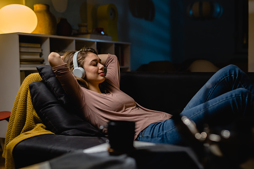 woman relaxing at home, listening to music